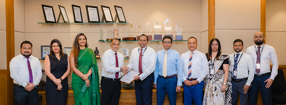 L to R: Mr. Ranjan Dahanayake, Deputy Managing Director – Sales and Marketing, Prime EV Automobiles (Pvt) Ltd (fourth from left), and Mr. Deepal De Silva, Chief Operating Officer, Sampath Bank (sixth from right), exchange the agreement in the presence of senior representatives from both organisations.