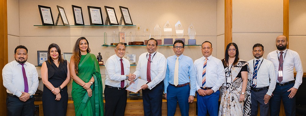 L to R: Mr. Ranjan Dahanayake, Deputy Managing Director – Sales and Marketing, Prime EV Automobiles (Pvt) Ltd (fourth from left), and Mr. Deepal De Silva, Chief Operating Officer, Sampath Bank (sixth from right), exchange the agreement in the presence of senior representatives from both organisations