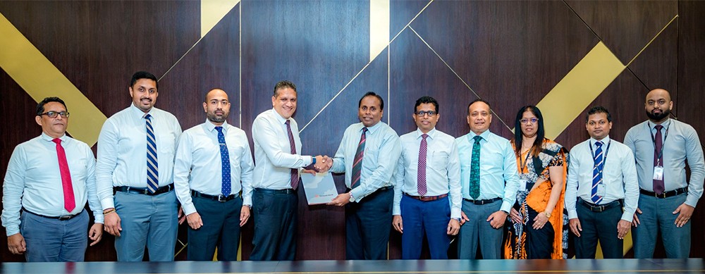 L to R: Mr. Dirk Joshua, Executive Director – Sales & Marketing, Sathosa Motors PLC (fourth from left), and Mr. Deepal De Silva, Chief Operating Officer, Sampath Bank (sixth from right), exchange the agreement in the presence of senior representatives from both organisations.