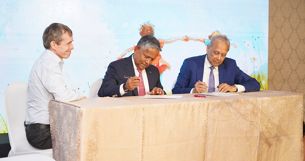 Mr. Dillip Rajakarier, Mr. Abbas Esufally, and Mr. Stevan Enderby signing the Memorandum of Understanding