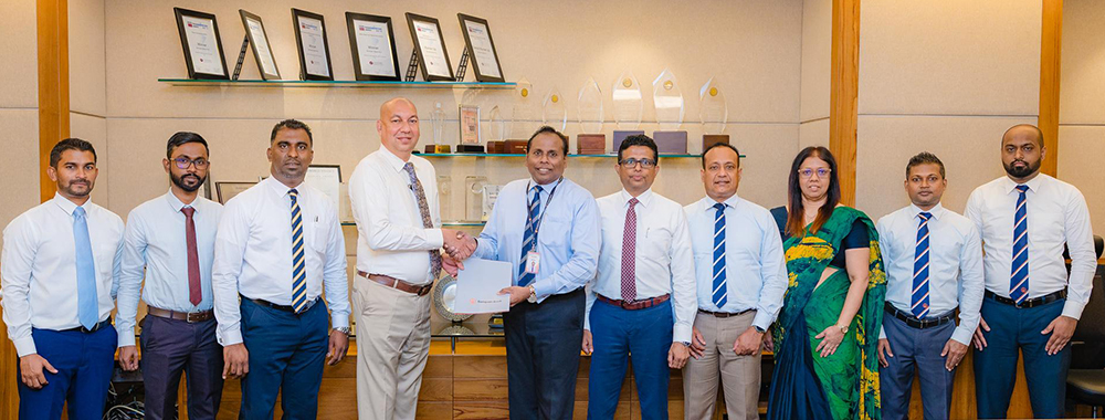 Mr. Asela Lihinikaduwa, Group Director – Micro Cars (Pvt) Ltd (Fourth from Left) and Mr. Deepal De Silva, Chief Operating Officer, Sampath Bank (Sixth from Right) exchange the agreement in the presence of representatives from both institutions