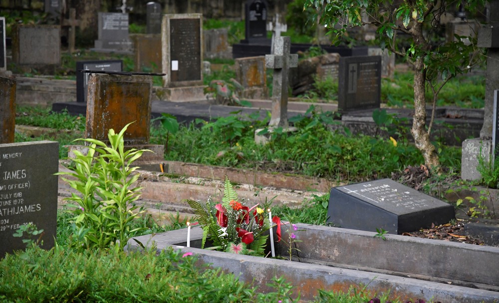 A grave brightened by flowers and candles of remembrance