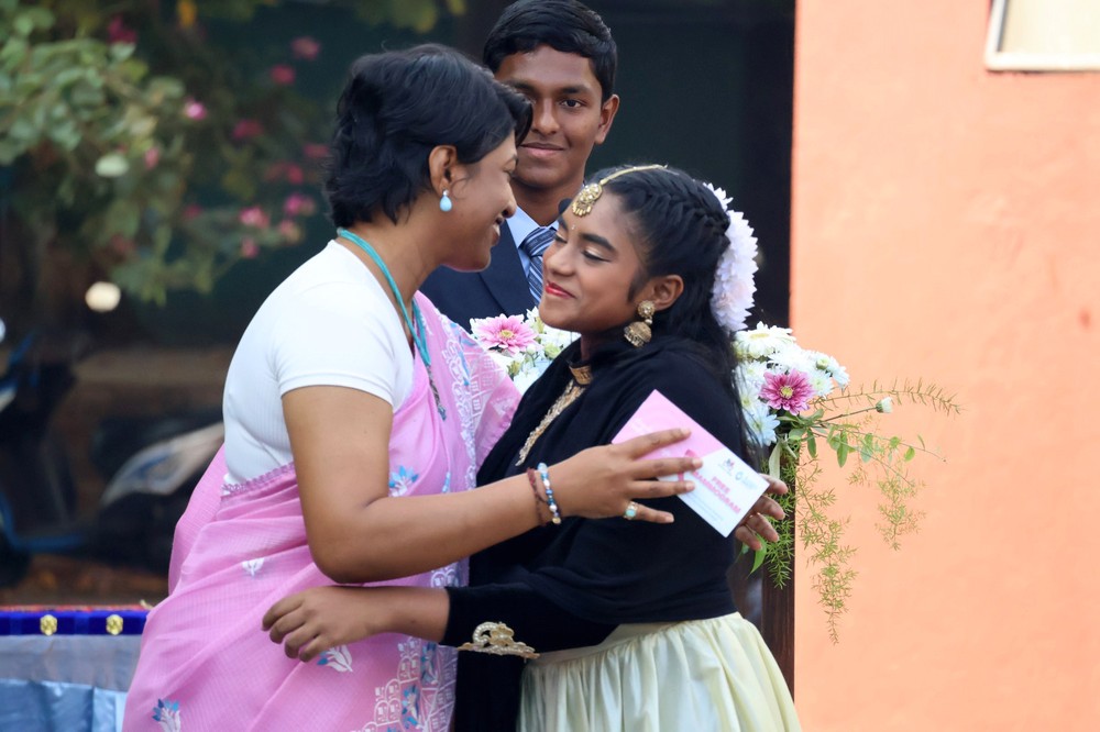 Student handing over voucher to her mother